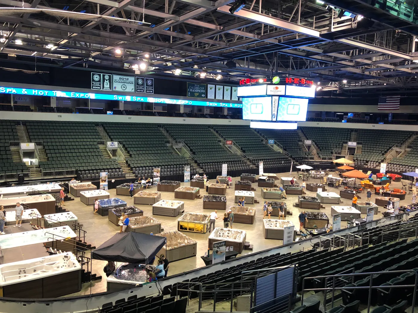 Hot tubs set up across an arena floor for a Paradise Spas sale event